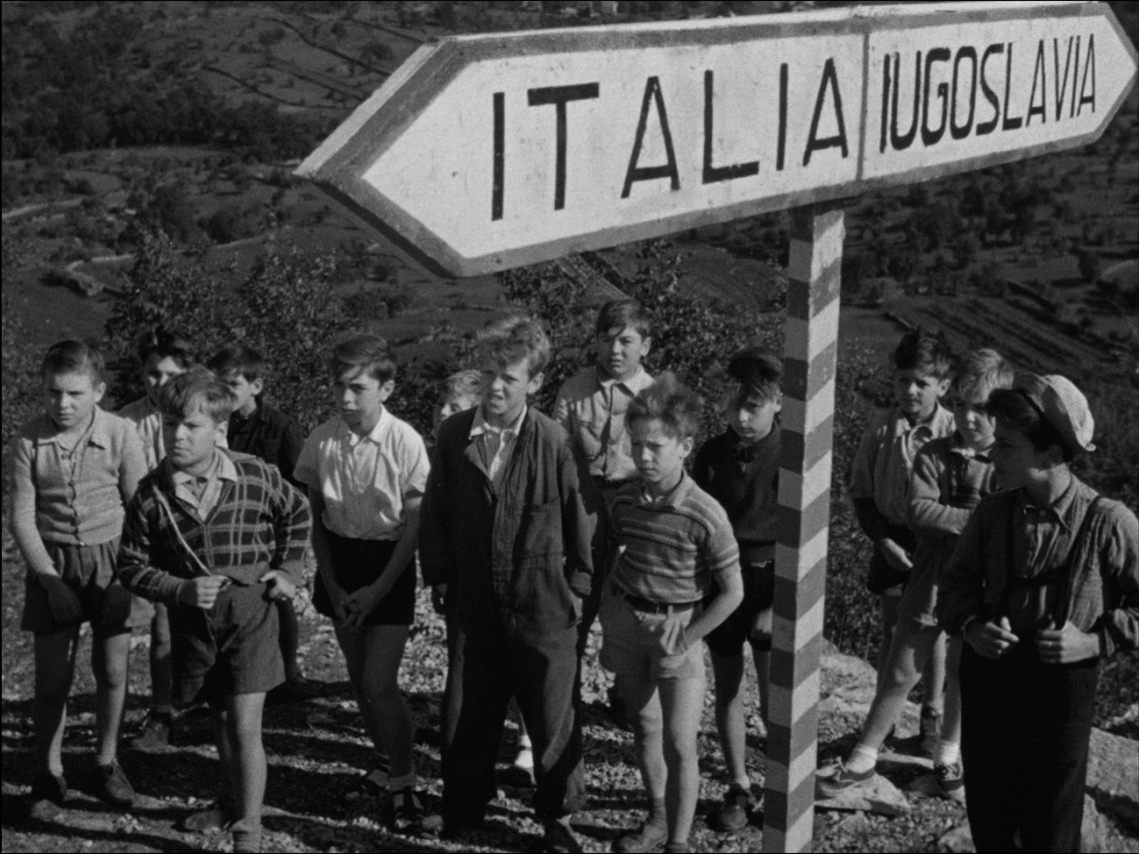 [P]Po drugi svetovni vojni v vasi na meji med Italijo in Jugoslavijo posebna komisija za razmejitev riše črto, ki bo vas razdelila na pol. V nekaj urah se bodo morali vaščani odločiti, ali bodo Italijani ali Jugoslovani. To pri ljudeh povzroča številne stiske. Eden od kmetov ima hišo na eni strani meje in njivo na drugi. Mladenič ima svojo ljubezen v drugi polovici naselja. Otroci so z vseh koncev vasi in niti oni se ne sprijaznijo s takšnimi spremembami.[/P]